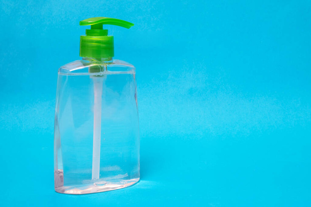 Green liquid soap dispenser on blue background, copy space - Foto, Imagem