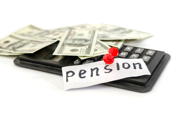 Concept de pension. Dollars avec une calculatrice et le mot "pension" sur blanc
. - Photo, image