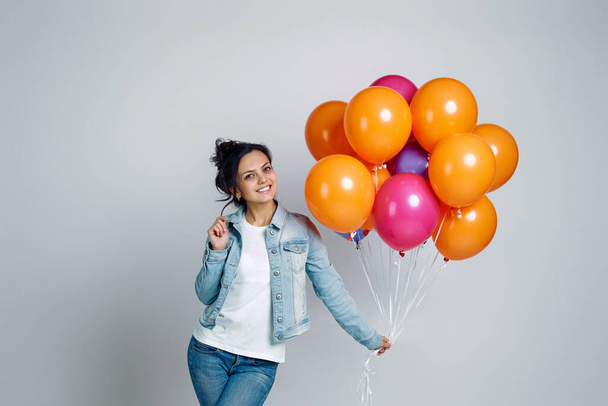 girl in denim posing with bright colorful air balloons - Foto, Bild