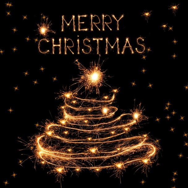 Christmas tree-shaped sparklers on black background - Фото, изображение