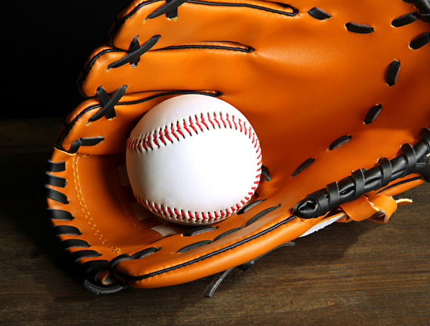 Baseball glove and ball on dark background - Fotoğraf, Görsel