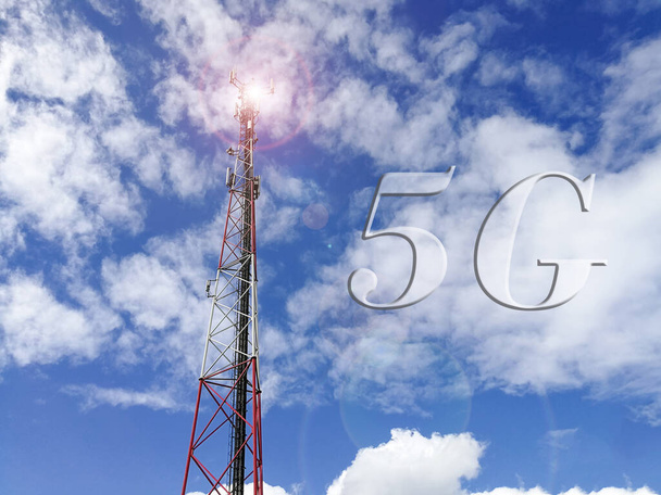Text 5G (5G technologie) se základnovou stanicí GSM (Global System for Mobile communication) a opakovací věží před modrou oblačnou oblohou - Fotografie, Obrázek