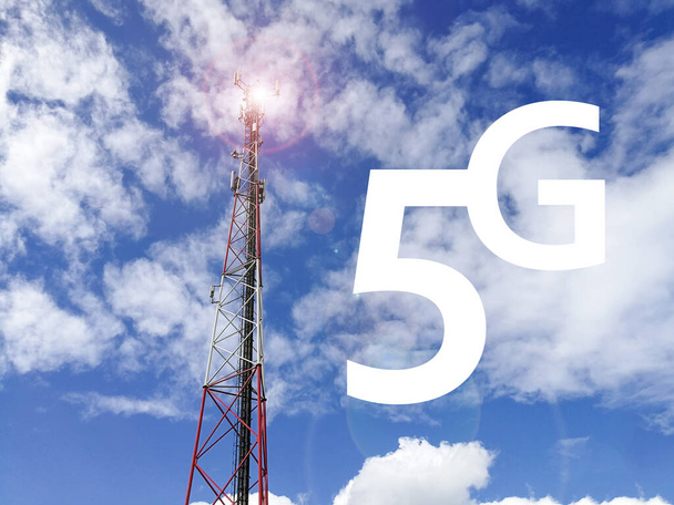 Texto 5G (tecnología 5G) con estación base GSM (Sistema Global de Comunicación Móvil) y torre repetidora frente al cielo azul nublado
 - Foto, Imagen