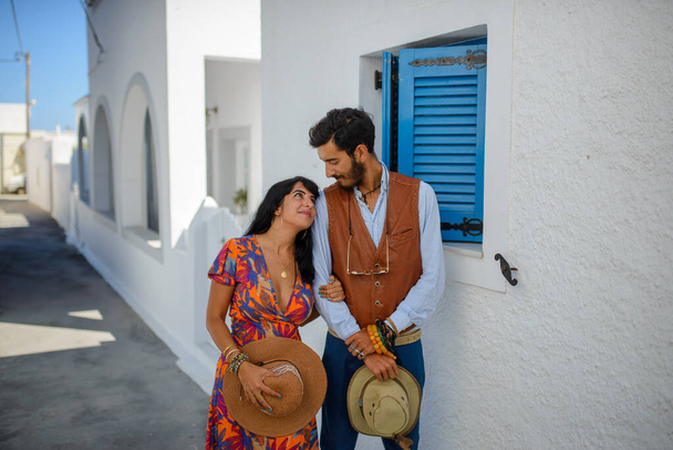 サントリーニ島のImerovigli村の通りに男と女がポーズをとっています - 写真・画像