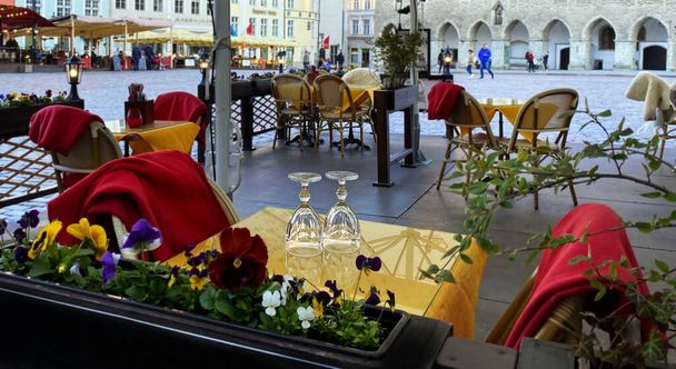 Летний уличный ресторан на стаканах на столе Люди расслабляющие кафе цветы украшения летний сезон поездки в Европу городской образ жизни Таллинн старый город, Эстония
  - Фото, изображение
