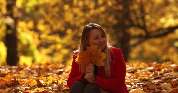 Piękna młoda matka idzie na spacer w jesiennym parku - Materiał filmowy, wideo