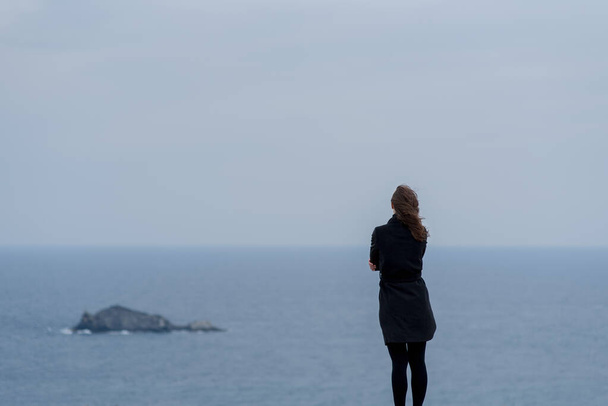 jeune femme debout contre un ciel bleu et la mer
  - Photo, image