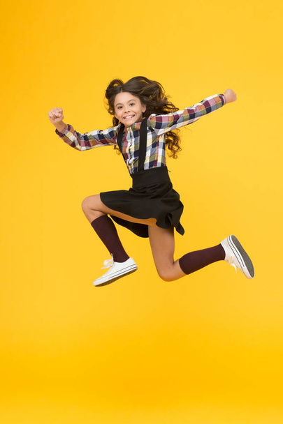 Be happy everyday. Happy child in midair yellow background. Having fun. Happy childhood. Raising happy kid. School holidays. International childrens day - Photo, image