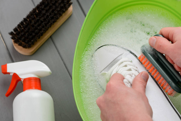 Hand washing of white canvas sneakers. Footwear cleaning tutorial concept - Fotografie, Obrázek