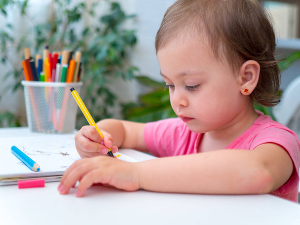 Dibujo de niña con marcadores en casa. Concepto de creatividad infantil
 - Foto, imagen