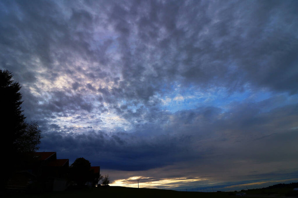Sötét viharfelhők az égen a naplemente felett - Fotó, kép