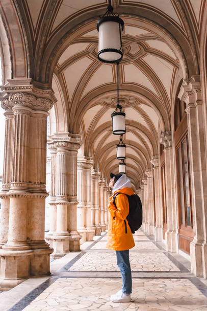 donna turista a piedi con zaino in impermeabile giallo città turismo copia spazio - Foto, immagini