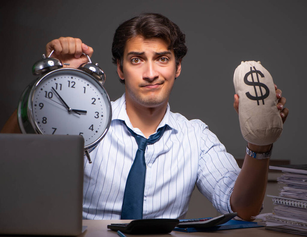 Joven gerente financiero trabajando hasta tarde en la noche en la oficina
 - Foto, imagen