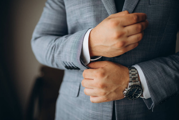 Close-up of a man in a tux fixing his cufflink. groom bow tie cufflinks. - 写真・画像