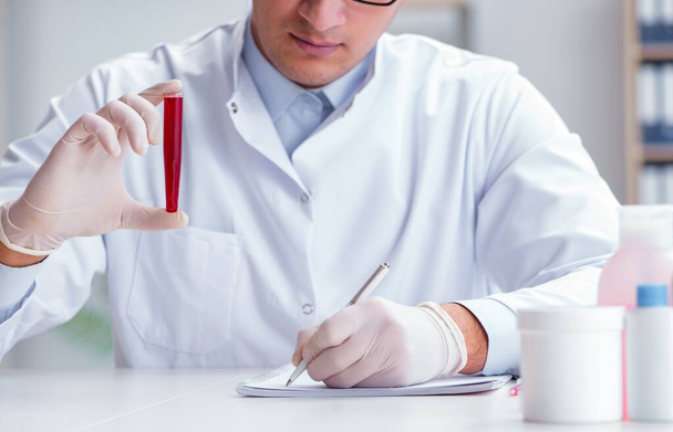 Młody lekarz w laboratorium z red tube - Zdjęcie, obraz