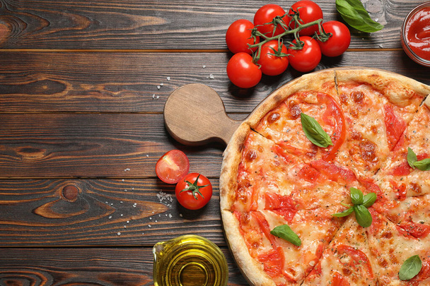 Delicious pizza Margherita and ingredients on wooden table, flat lay. Space for text - Фото, изображение