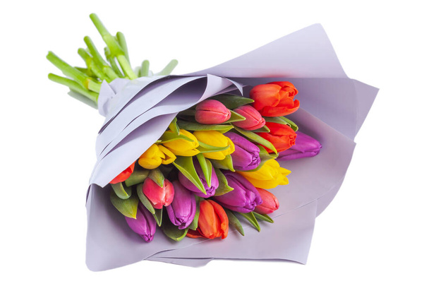 bouquet of multicolored tulips wrapped in light purple paper on a white background, isolate - Valokuva, kuva