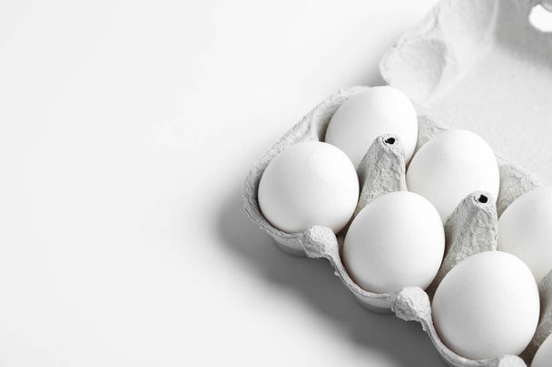 Fresh chicken eggs in box on white background. Space for text - Foto, immagini