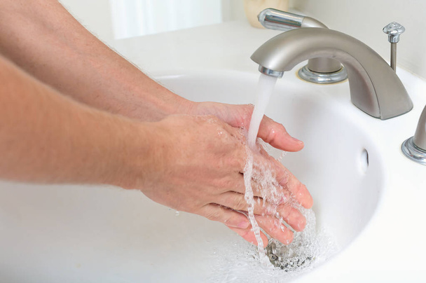 Person wäscht sich die Hände mit Seife und Wasser - Foto, Bild
