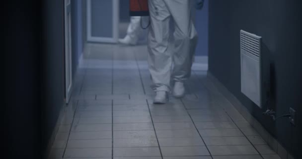 Hombres con trajes de materiales peligrosos desinfectando corredor
 - Imágenes, Vídeo