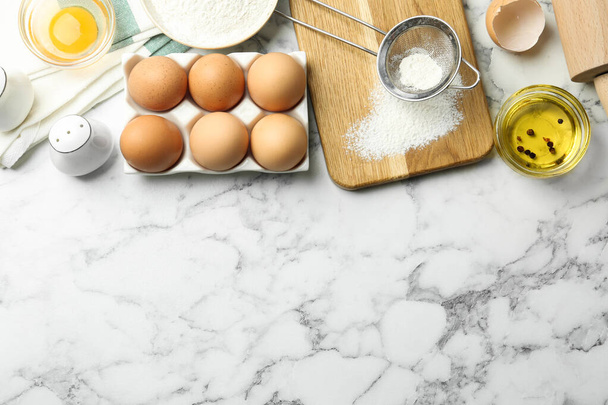Flat lay composition with chicken eggs on white marble table. Space for text - Foto, Bild