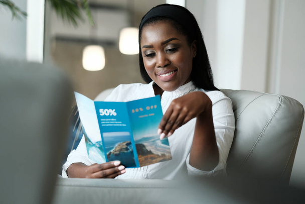 Czarna kobieta czyta ulotki podróży na wakacje podróży - Zdjęcie, obraz