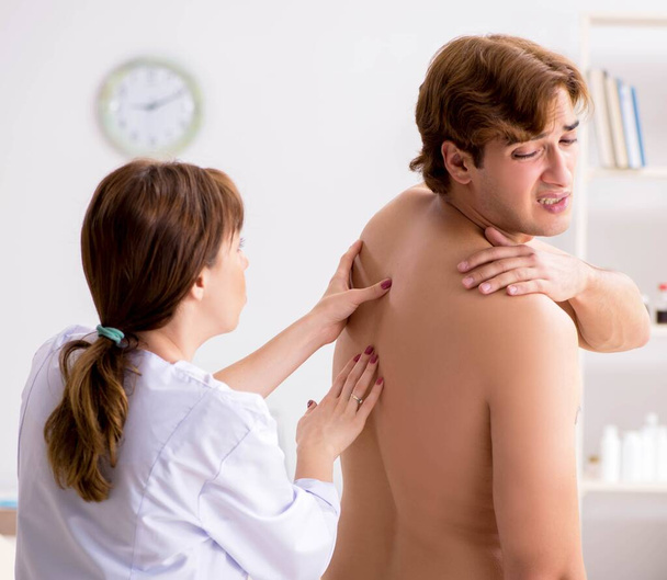 Young female doctor chiropractor massaging male patient - Foto, Imagen