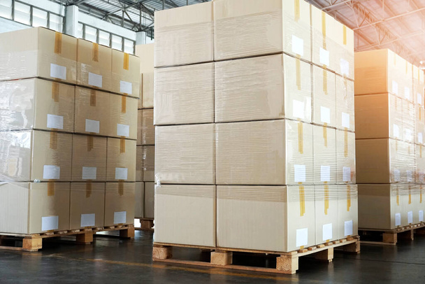 Stack of cardboard boxes on wooden pallets, package, packaging cartons, interior of warehouse storage, manufacturing plant shipping logistics and transport - Photo, Image