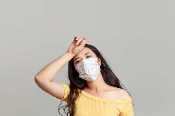 顔のマスクを身に着けている若いアジアの女性は、自分自身を保護し、隔離するフル、コヴィト-19 、インフルエンザを形成する。彼女は世界的なパンデミックを心配しています.  - 写真・画像