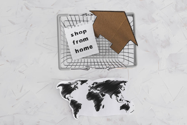 допомога бізнесу після глобального блокування, викликаного коїдом-19, сумки для покупок зі світовою картою та значком будинку з магазином з домашнього повідомлення
 - Фото, зображення