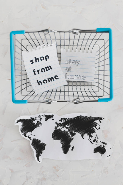 βοηθώντας τις επιχειρήσεις μετά το παγκόσμιο κλείδωμα που προκαλείται από covid-19, τσάντες ψώνια και παγκόσμιο χάρτη με Κατάστημα από το σπίτι και Stay Home μήνυμα - Φωτογραφία, εικόνα
