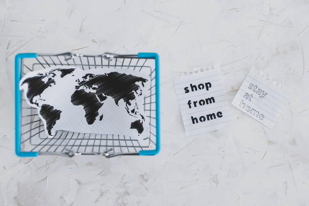 допомога бізнесу після глобального блокування, спричиненого коїдом-19, сумки для покупок та карта світу з магазином з дому та повідомленням про перебування вдома
 - Фото, зображення