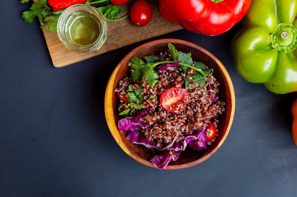 Red quinoa salad with tomato on a rustic table. Superfood and healthy eating concept. - Photo, Image