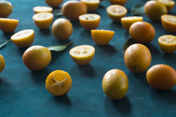 un sacco di kumquat su uno sfondo azzurro. frutta fresca
. - Foto, immagini