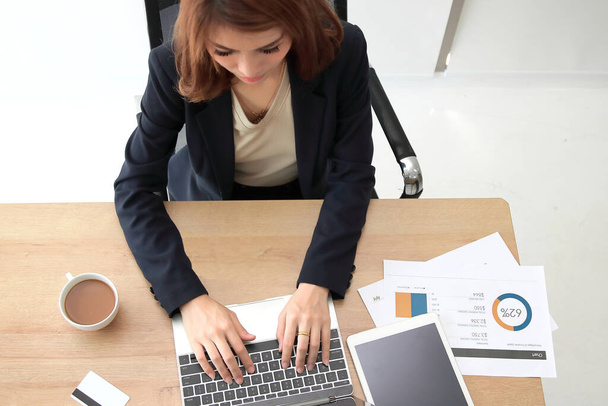 Vue aérienne d'une femme d'affaires asiatique travaillant avec un ordinateur portable sur le lieu de travail au bureau
. - Photo, image