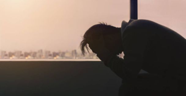 Blur background young depressed asian man sitting alone near window in evening time with low light environment, PTSD Mental health concept. - Photo, Image