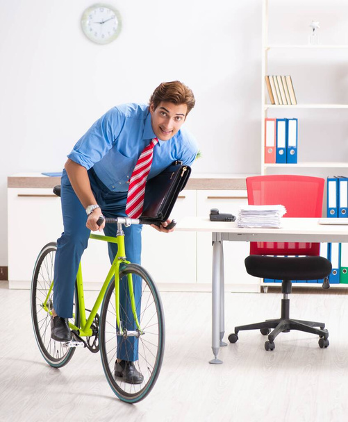 Egy fiatal üzletember biciklivel jár az irodába. - Fotó, kép