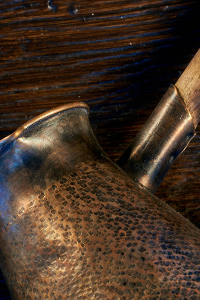 Old copper turk for making coffee. background. macro-photo. side view. part of a metal product. - Photo, Image