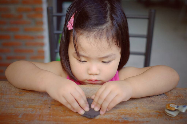 陶器のクラスのかわいいアジアの女の子、動物に彼女の粘土を成形.  - 写真・画像