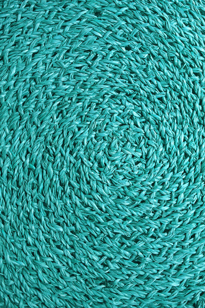 Vertical image of spiral texture of turquoise blue colored woven water hyacinth place mat - Photo, Image