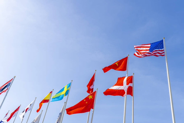 Mavi gökyüzü arka planına sahip uluslararası bayrak direği  - Fotoğraf, Görsel
