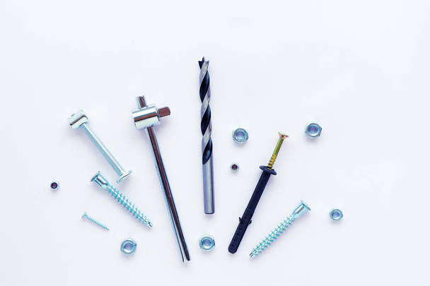 Different screws, bolts, nuts, drill, tools on a white backgroun - Fotó, kép