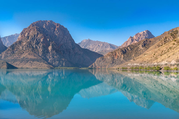 A vista panorâmica do lago Iskanderkul e das montanhas Fann no Tajiquistão
 - Foto, Imagem