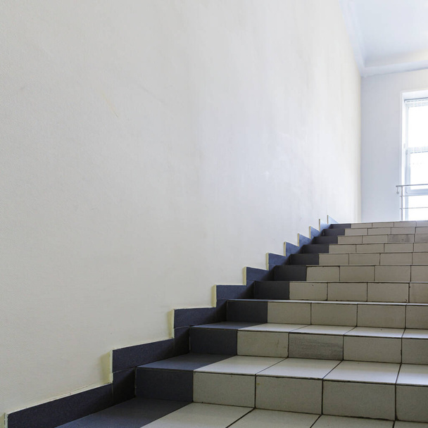 O conceito do interior de um edifício urbano. Foto de uma escadaria com corrimão de metal entre pisos
. - Foto, Imagem