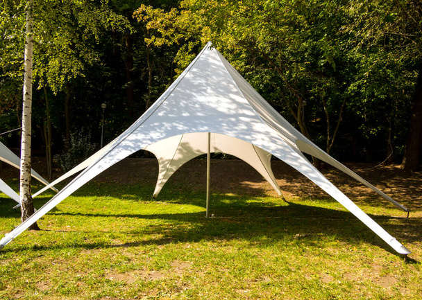 Tenda de tenda feita de tecido leve fica em uma clareira
 - Foto, Imagem