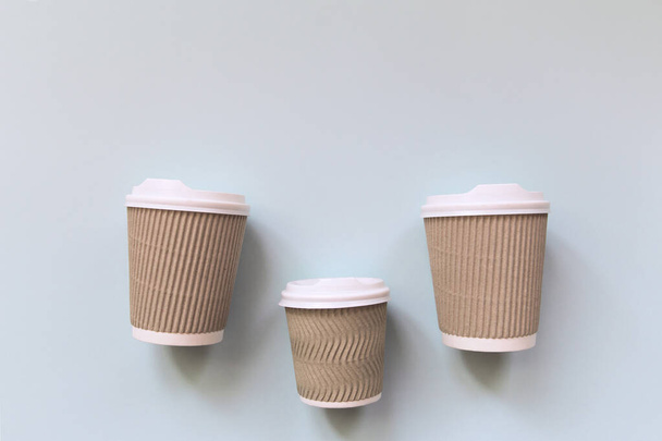 Paper cups of coffee to go on pastel background. Flat lay. - Photo, Image