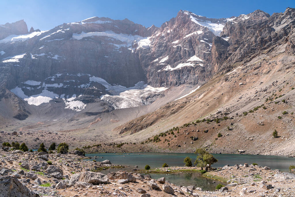 A gyönyörű hegymászó út tiszta kék ég és sziklás dombok és friss hegyi tó Fann hegyek Tádzsikisztánban - Fotó, kép
