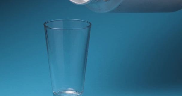 Milk is poured into a milk glass on a blue background. - Imágenes, Vídeo