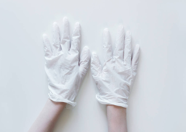 Χέρια σε λευκά ιατρικά γάντια σε λευκό φόντο - Φωτογραφία, εικόνα