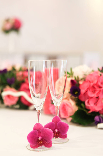 Весільні окуляри прикрашені живими орхідеями на фоні, прикрашені таблицею квіткових композицій
 - Фото, зображення